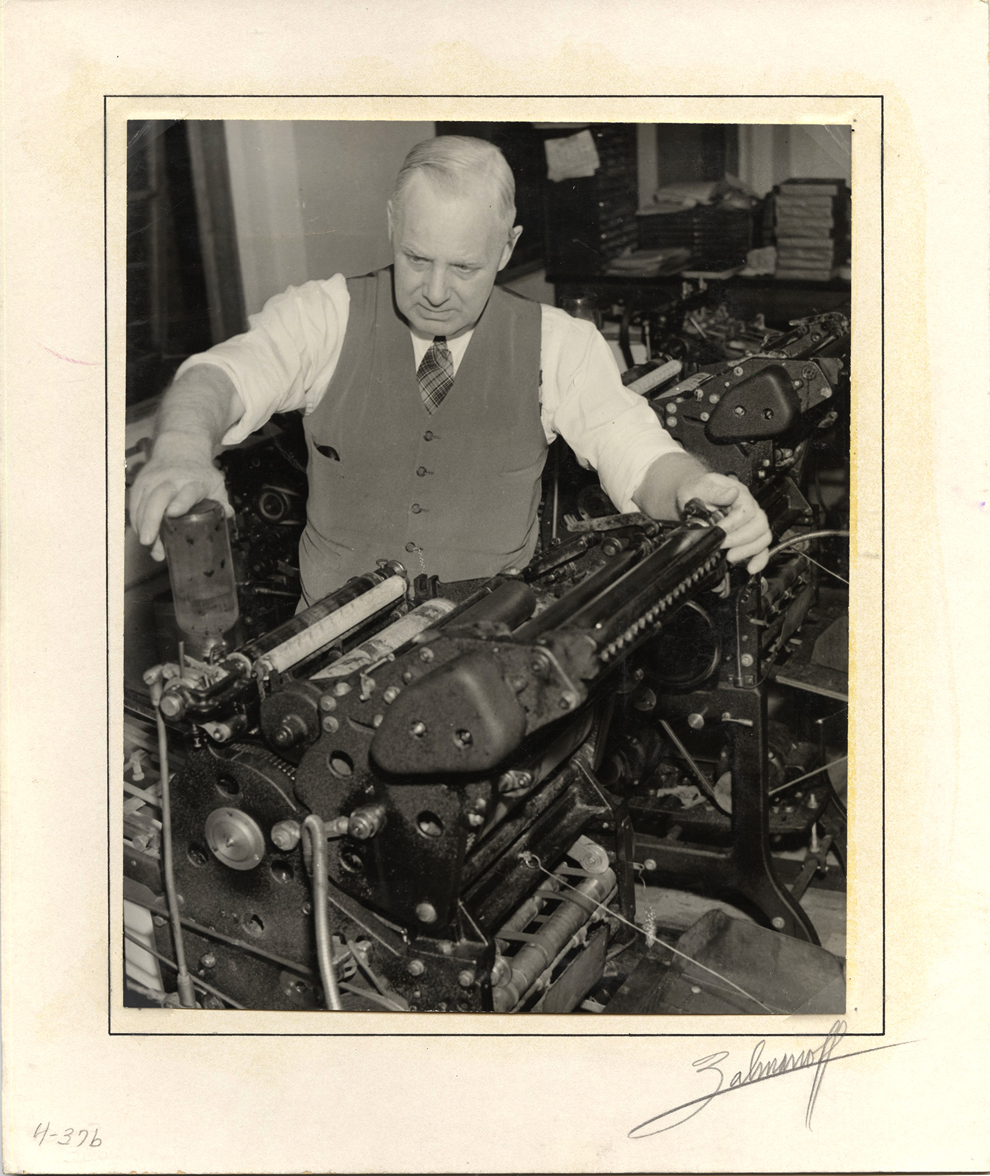Photograph of Frank B. Robinson loading a printing press with ink