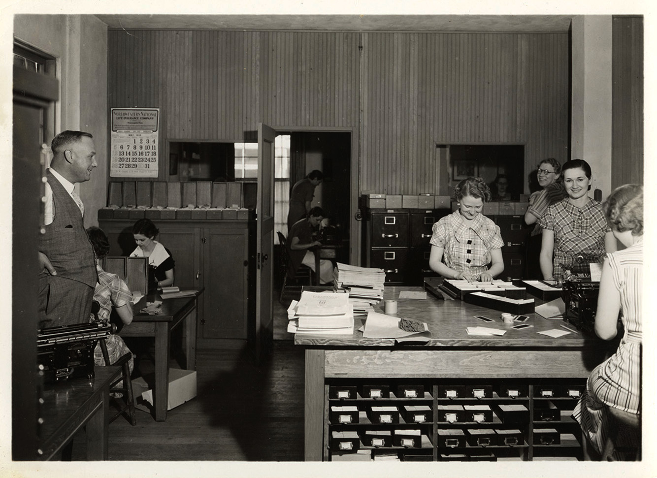 Photograph of Frank B. Robinson watching Psychiana staff members work
